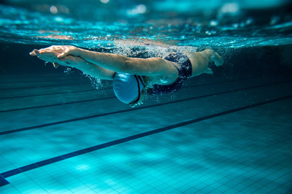 游泳池中练习游泳的运动员高清图片