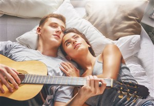 抱着吉他躺床上的欧美情侣图片