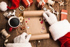 正在礼物盒上做装饰的圣诞老人高清摄影图片