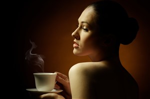 美女吹着咖啡杯热气图片