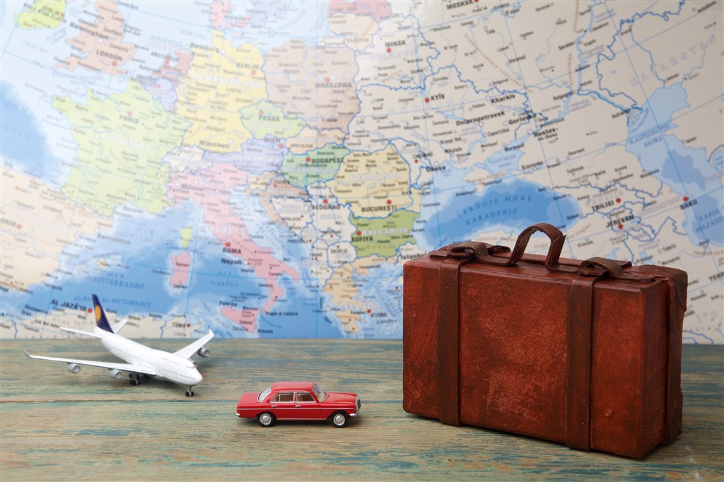 世界地图背景上的行李箱和交通工具模型高清图片 
