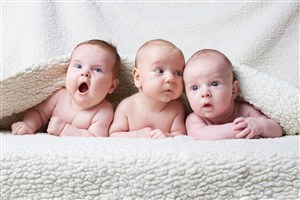 三个光着身子盖着毛毯的可爱婴儿高清图片