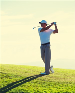 草坪上挥杆打高尔夫球的男士高清图片