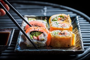 被筷子夹着的寿司特写摄影高清图片