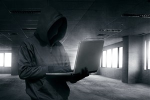 站在水泥建筑中操作电脑的黑客高清图片
