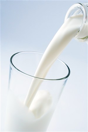 倒进玻璃杯的牛奶高清图片