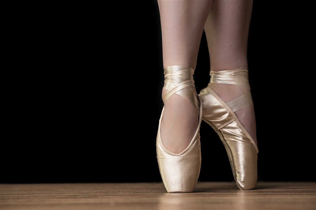 穿着金色芭蕾舞些脚尖站立的女性高清图片