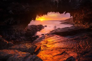 高清唯美海边日落晚霞岩洞风景图片