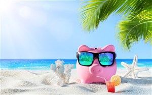 沙滩上戴着墨镜的小猪存钱罐 