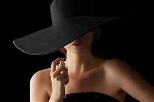 戴着黑色帽子正在喷香水的美女