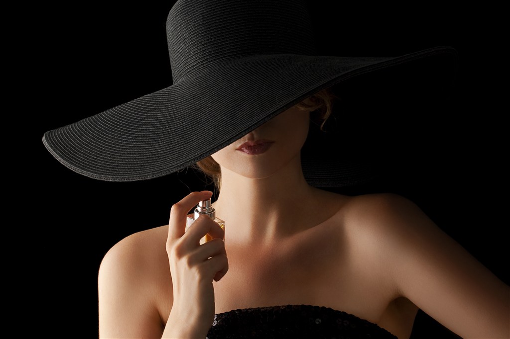戴着黑色帽子正在喷香水的美女