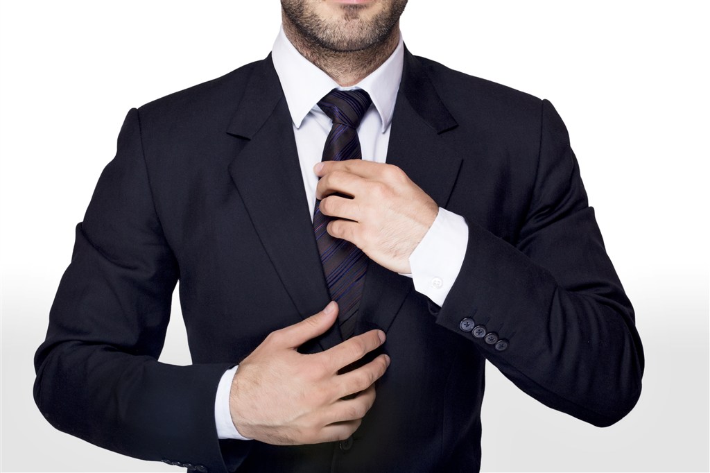 整理领带穿西服的商务男人图片