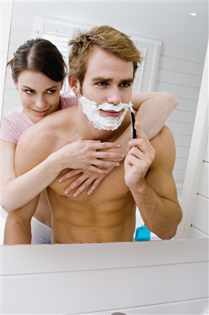 女人抱着正在剃须刮胡子的男人图片