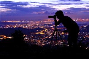 正在拍城市夜景的职业人物拿相机摄影师图片