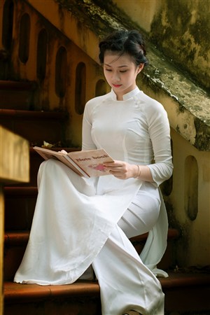 坐在楼梯间看书的越南旗袍美女