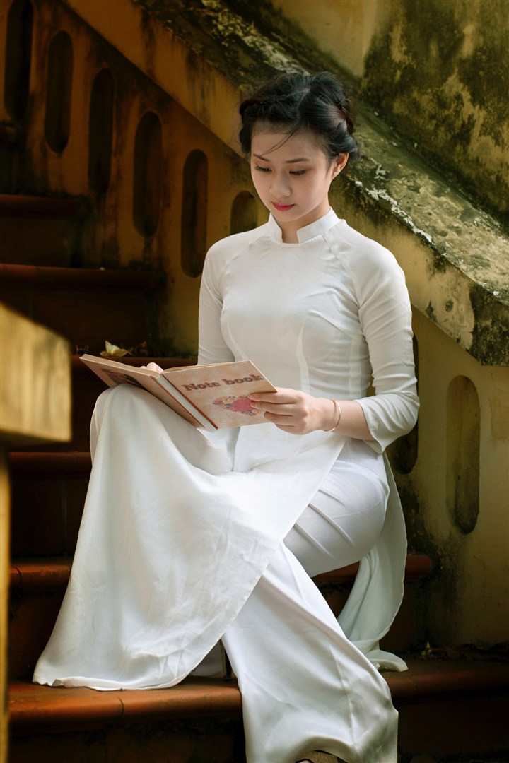坐在楼梯间看书的越南旗袍美女