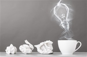 灰色背景上的纸团和咖啡杯里冒出的雾气高清图片