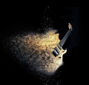 黑色背景上碎成粉末的吉他 