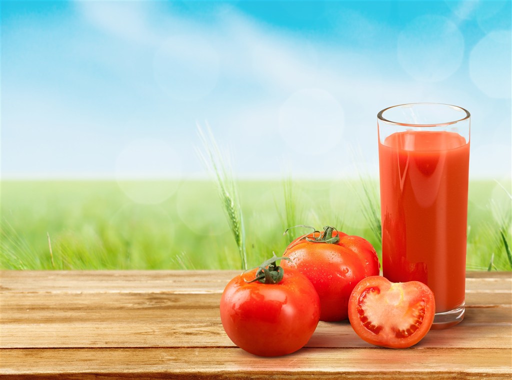 大自然背景上的番茄和杯子里的番茄汁高清图片