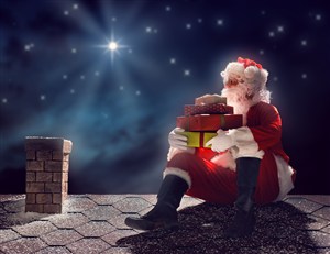 抱着礼盒坐在屋顶上的圣诞老人