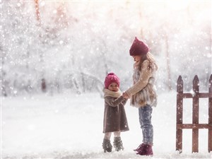雪地中两个小孩牵手的高清图片