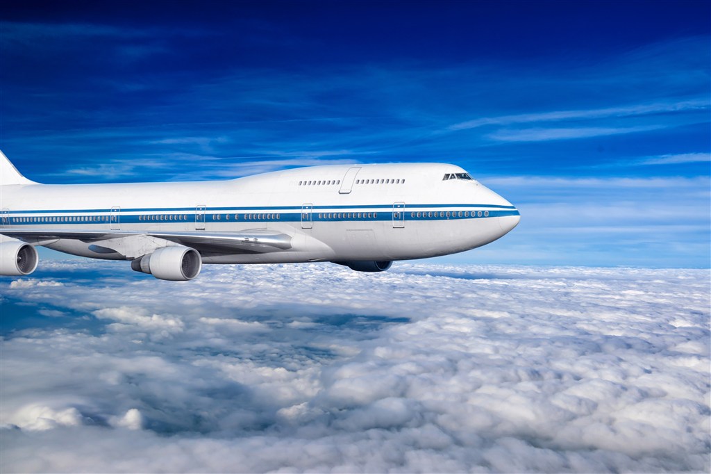 云层上飞行的白色客机高清图片