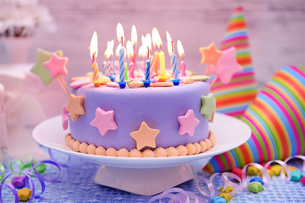 很多蜡烛的紫色生日蛋糕图片