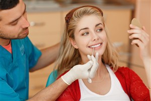 用工具为女患者检查牙齿的男医
