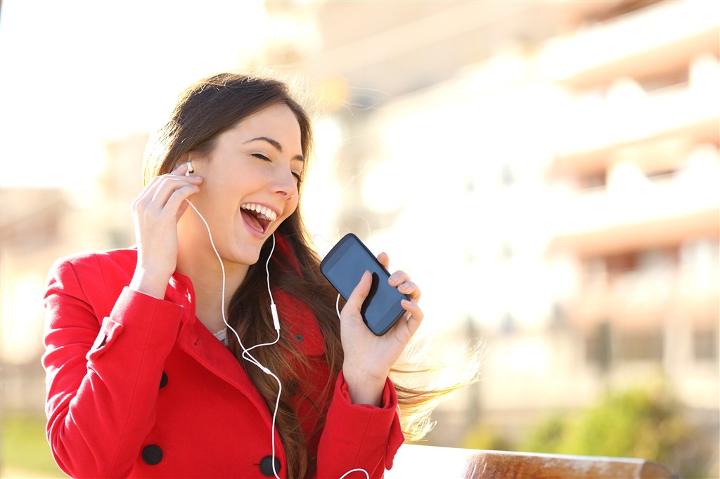 穿红衣服戴耳机听音乐的外国女性高清摄影图片