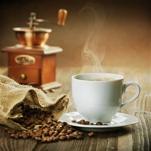咖啡豆旁边冒着香气的白色咖啡高清摄影图片