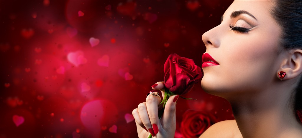 手拿鲜红的玫瑰花的美女模特 