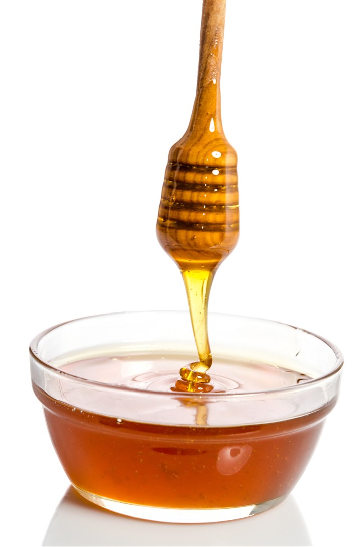用蜂蜜棒搅拌碗里蜂蜜高清摄影