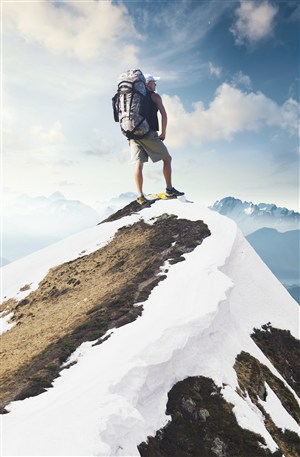 雪山顶上的背包客高清摄影图片