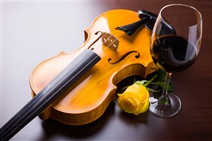 放在小提琴旁边的红酒杯 