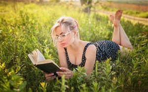 爬在草地上看书的欧美美女