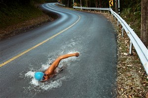 正在大马路上游泳的运动员创意高清图片